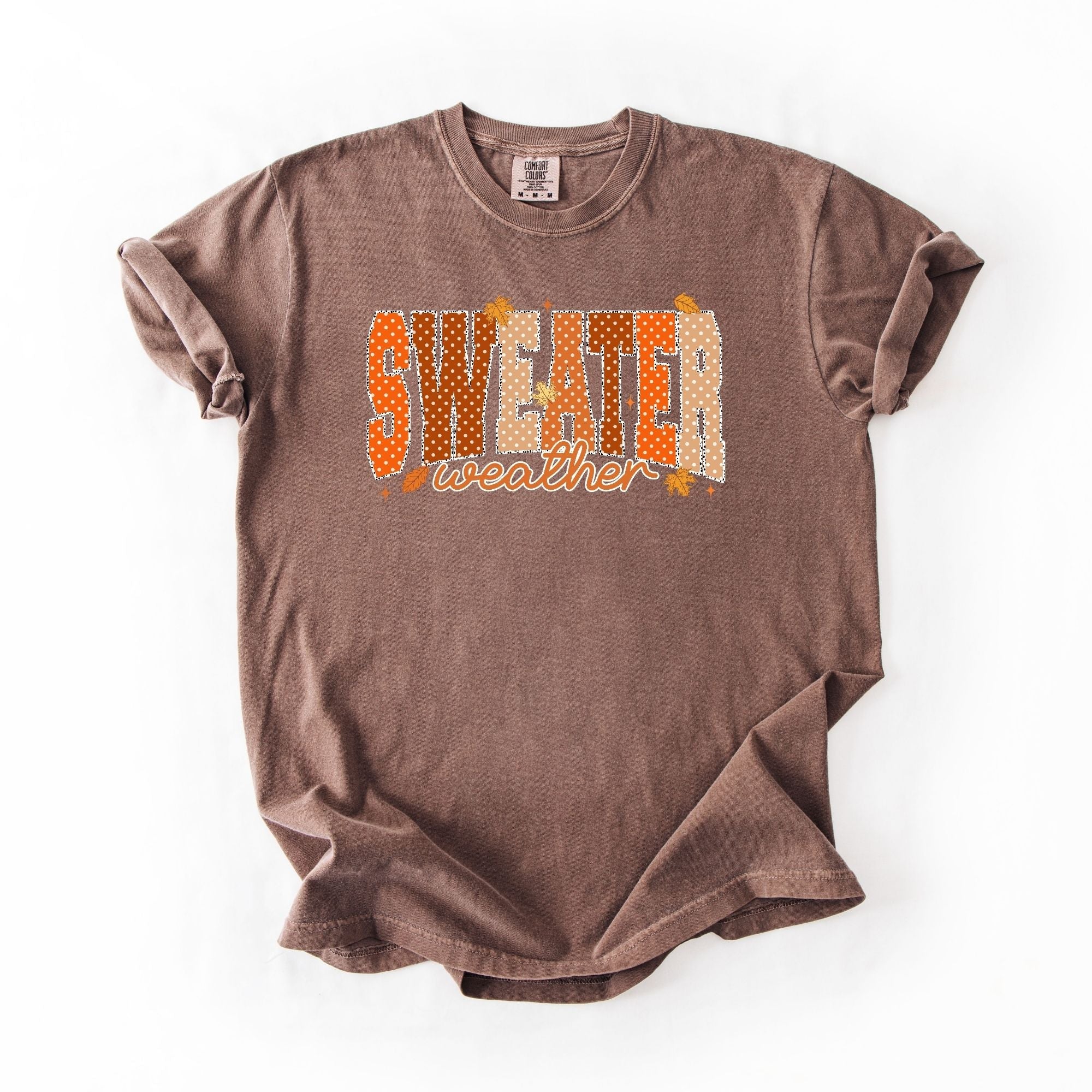 Brown Comfort Colors tee with SWEATER weather bold polka dot patterned block letters in orange and cream with fall maple leaves