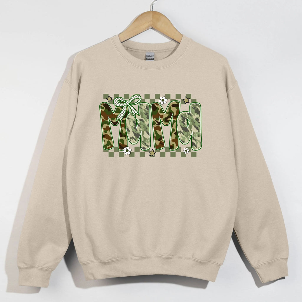 Sand Gildan crewneck sweatshirt on hanger with MAMA in camo patterned bubble letters on green checkered background with polka dot bow daisies and stars
