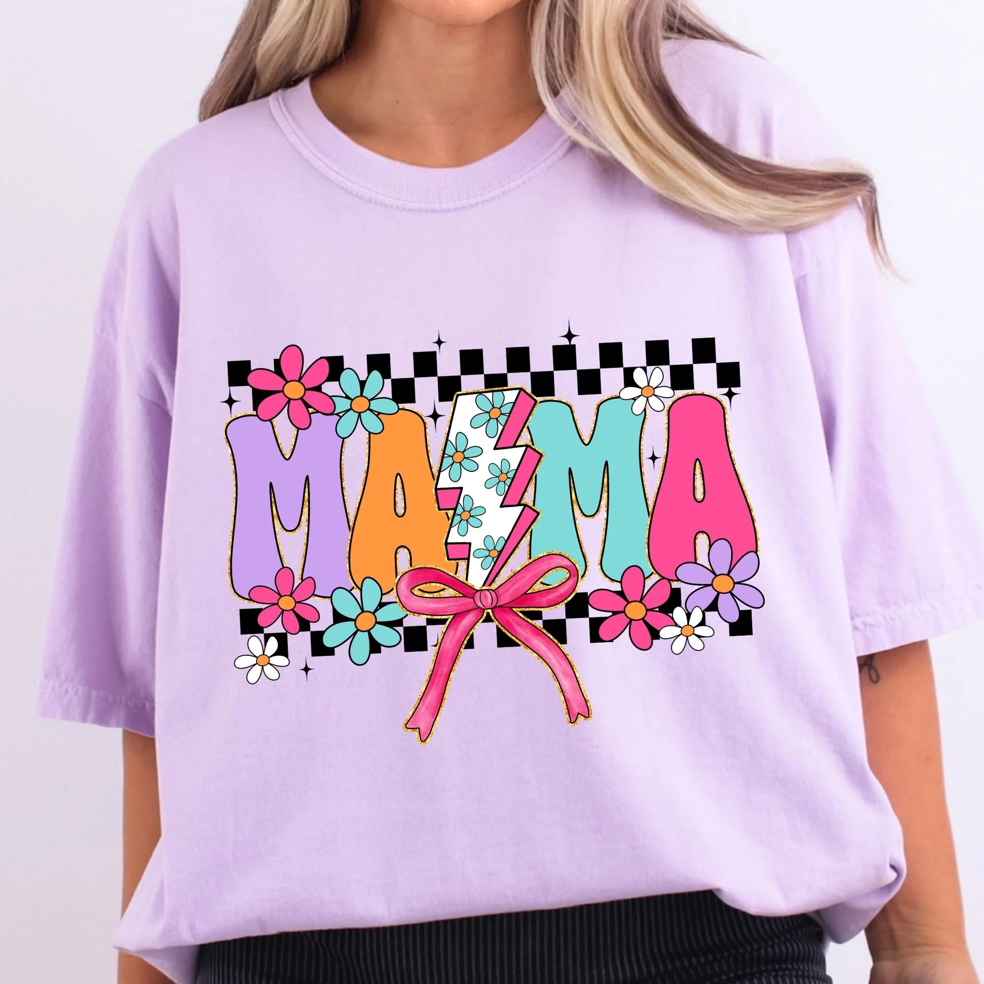 Lavender Comfort Colors oversized tee with retro MAMA graphic in colorful block letters on black checkered background with daisies lightning bolt and pink coquette bow