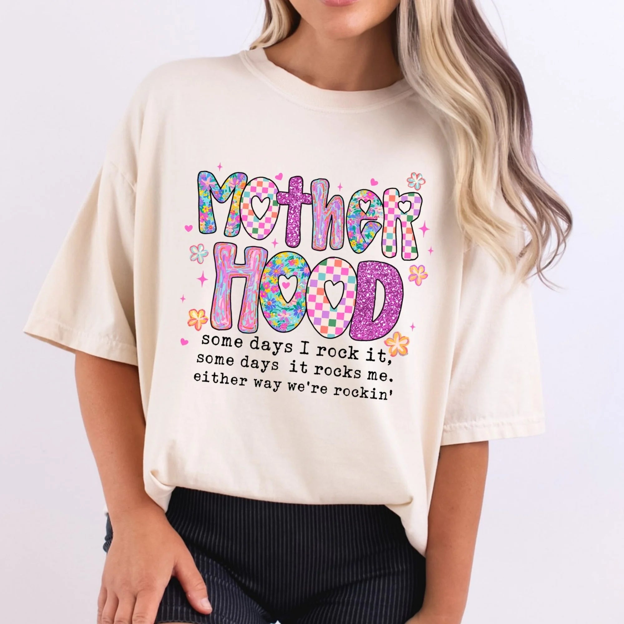 Ivory Comfort Colors oversized tee with colorful Motherhood graphic in checkered floral and glitter patterned letters with quote some days I rock it some days it rocks me either way we're rockin'