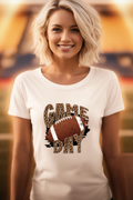Woman smiling at stadium wearing white Game Day leopard print football graphic tee