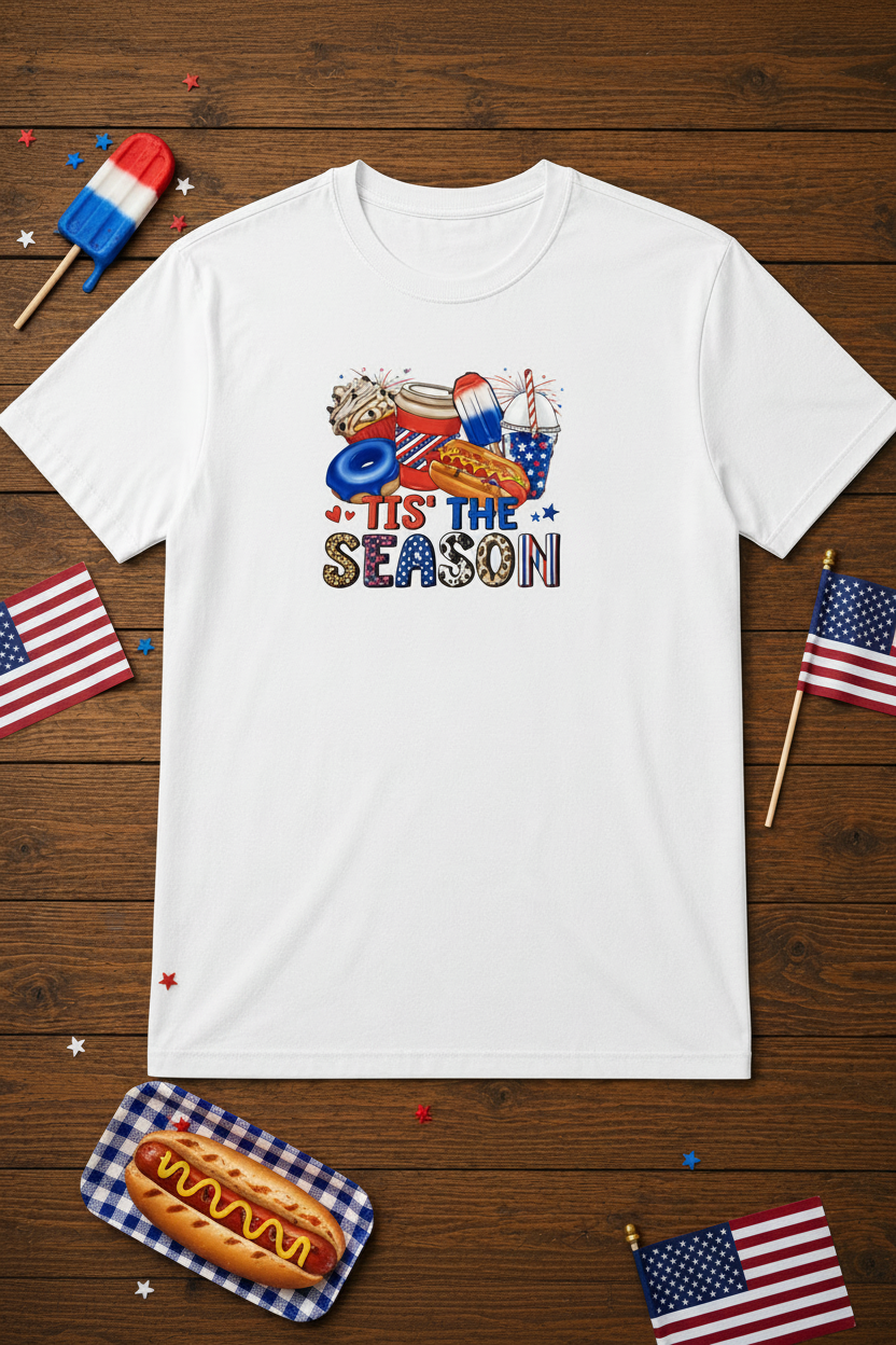 Tis' The Season T-Shirt styled with popsicle, hot dog, flags, and confetti on rustic wood