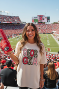 Woman at college football game wearing Georgia leopard football letters ivory tee