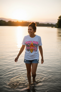 Woman wearing River Days Sun Rays tee outdoors near water