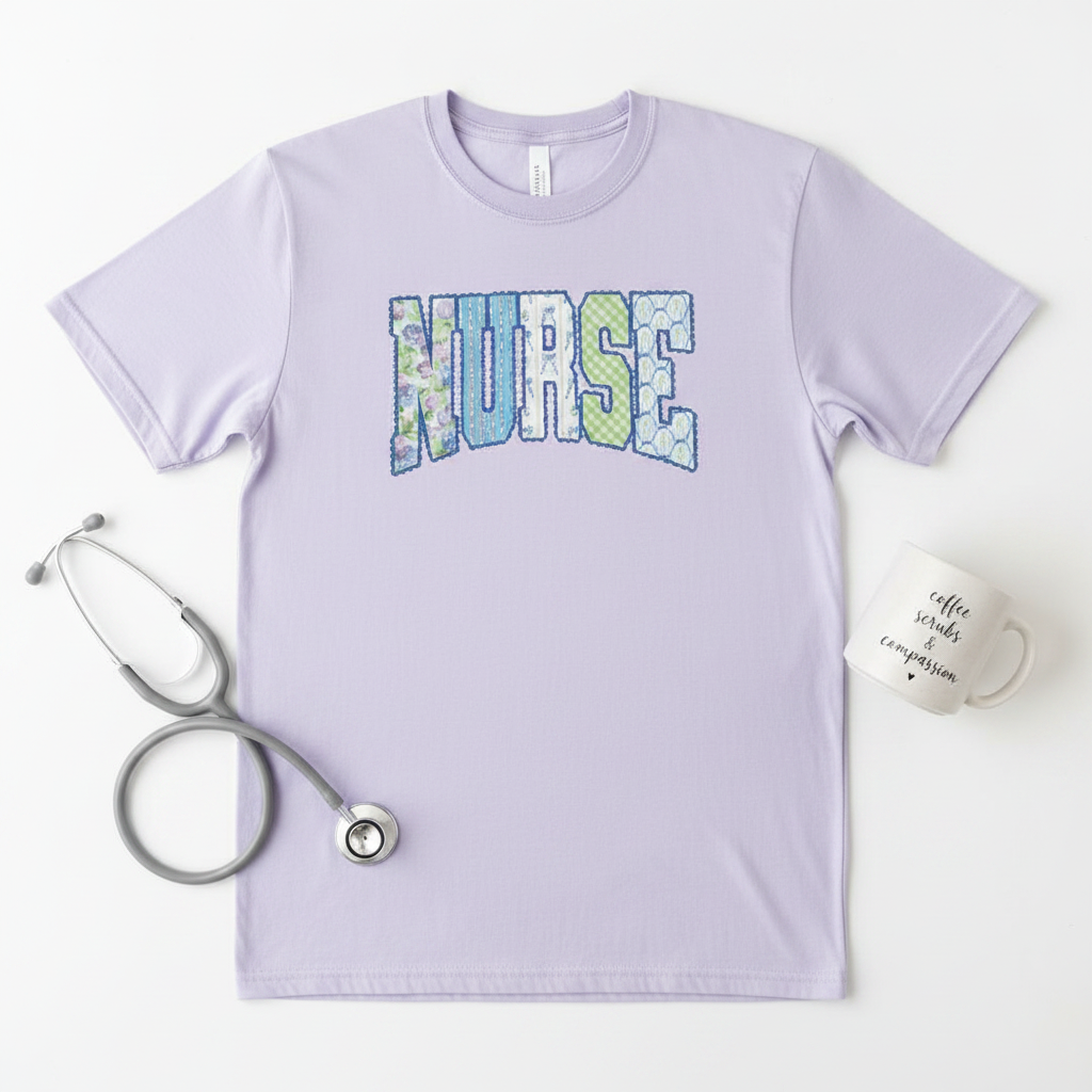 Flat lay of lavender nurse patchwork graphic tee on white background styled with stethoscope and coffee mug