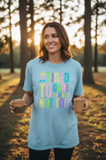 Woman wearing Too Tired To Care Anxious Not Too T-Shirt in light blue in a fun casual outdoor lifestyle photo
